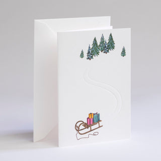 mit Geschenken beladener Schlitten in Winterlandschaft