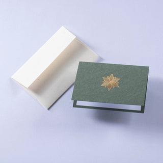 Prägung eines goldenen Sterns auf dunkelgrünem Papier