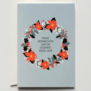 Weihnachtliche Grußkarte mit Kranz aus Christrosen und Ilex