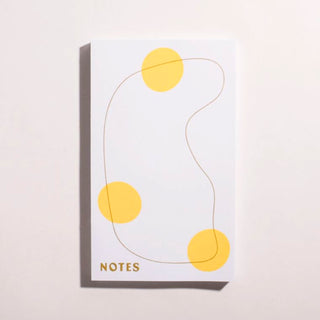 Notizblock mit gelben Punkten und olivgruener Linie