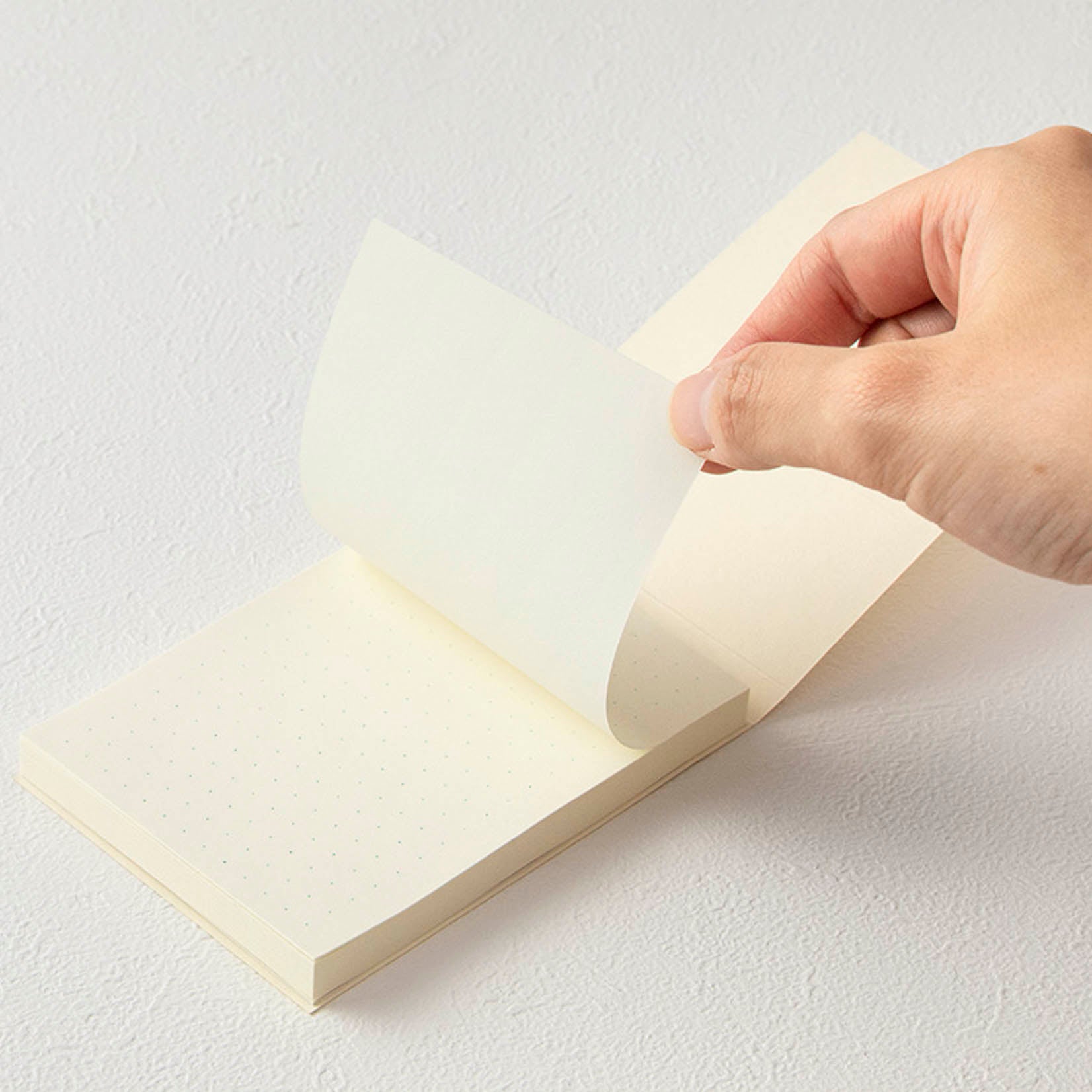 Haftnotizen auf cremefarbenem Papier mit Punktraster, verarbeitet zu einem BlockBlock 