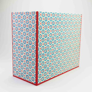 Die Box ist mit einem frischen blau-roten Blumenmuster bezogen.