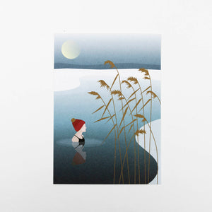 Eine Frau steht im winterlichen See mit roter Wollmütze